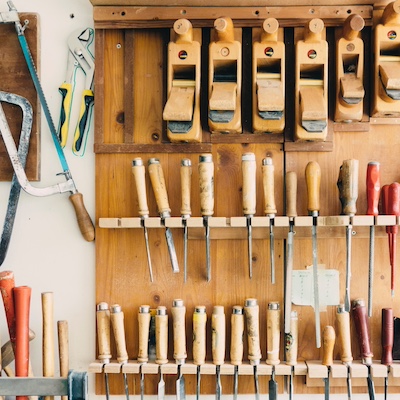  Assorted woodworking handheld tools in tool rack 