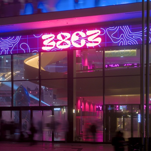  The entry of the conference hall where the 38c3 took place in Hamburg at night. The entry has a purple lid up sign that says 38c3. At the corner of the building you see 3 white glowing letters: CCC 