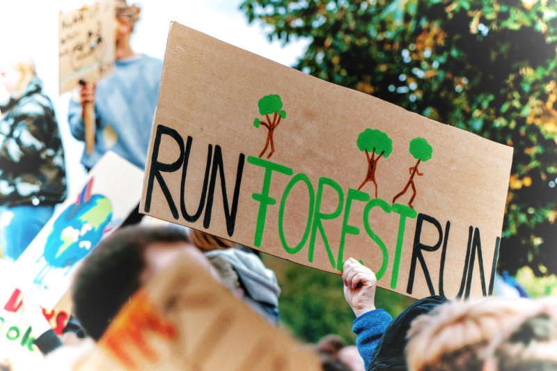  A foto of a protest, you see a person raising a sign. The sign says: Run Forrest Run. 